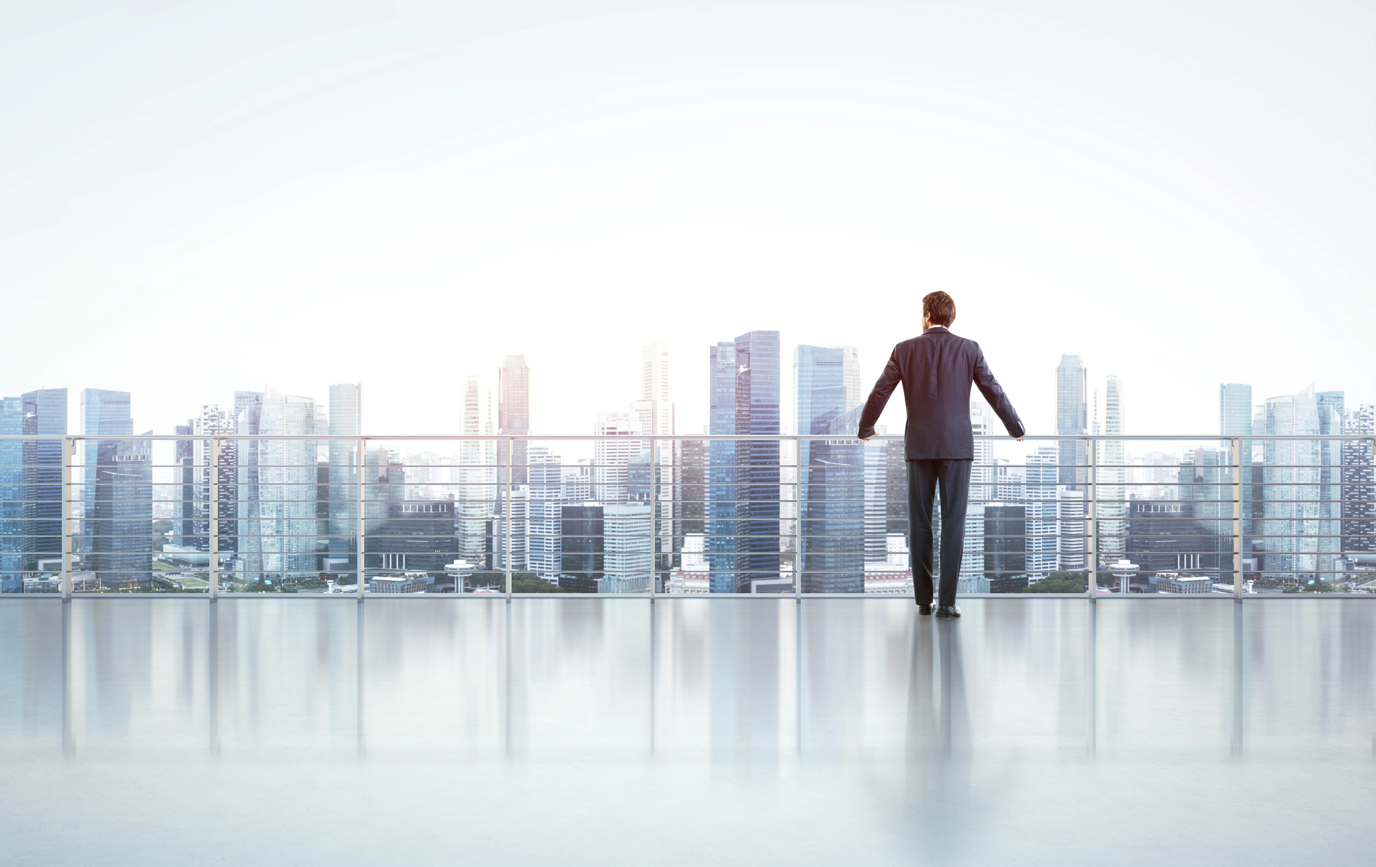 A man in a suit standing on a balcony.