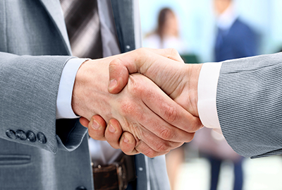 A close up of two people shaking hands.